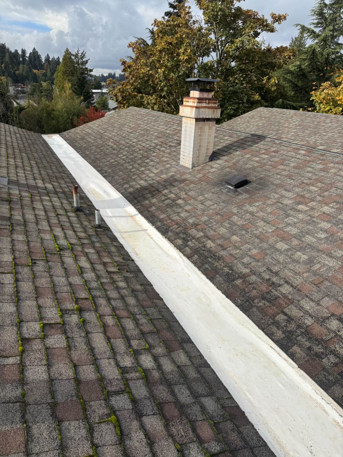 Same roof edge with the flat metal valley fully cleaned and brightened after service